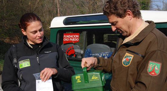 Dos colaboradores de la Fundación Oso Pardo entregando pastores a los cazadores