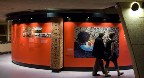 Dos visitantes pasand frente a las fotografías exuestas en la ExpoZaragoza 2008 sobre el problema del agua