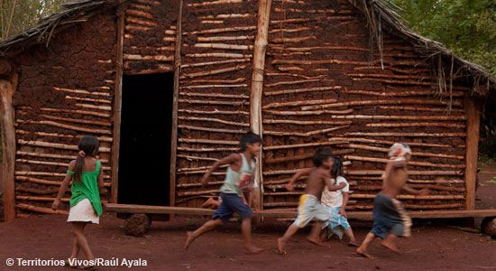 Niños de un poblado jugando delante de una choza