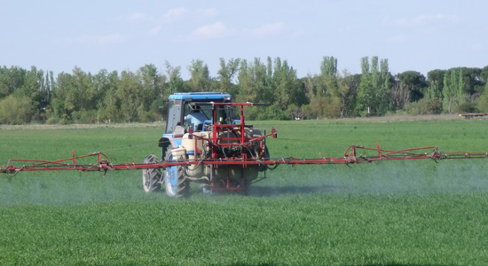 Un tractor fumigando el campo